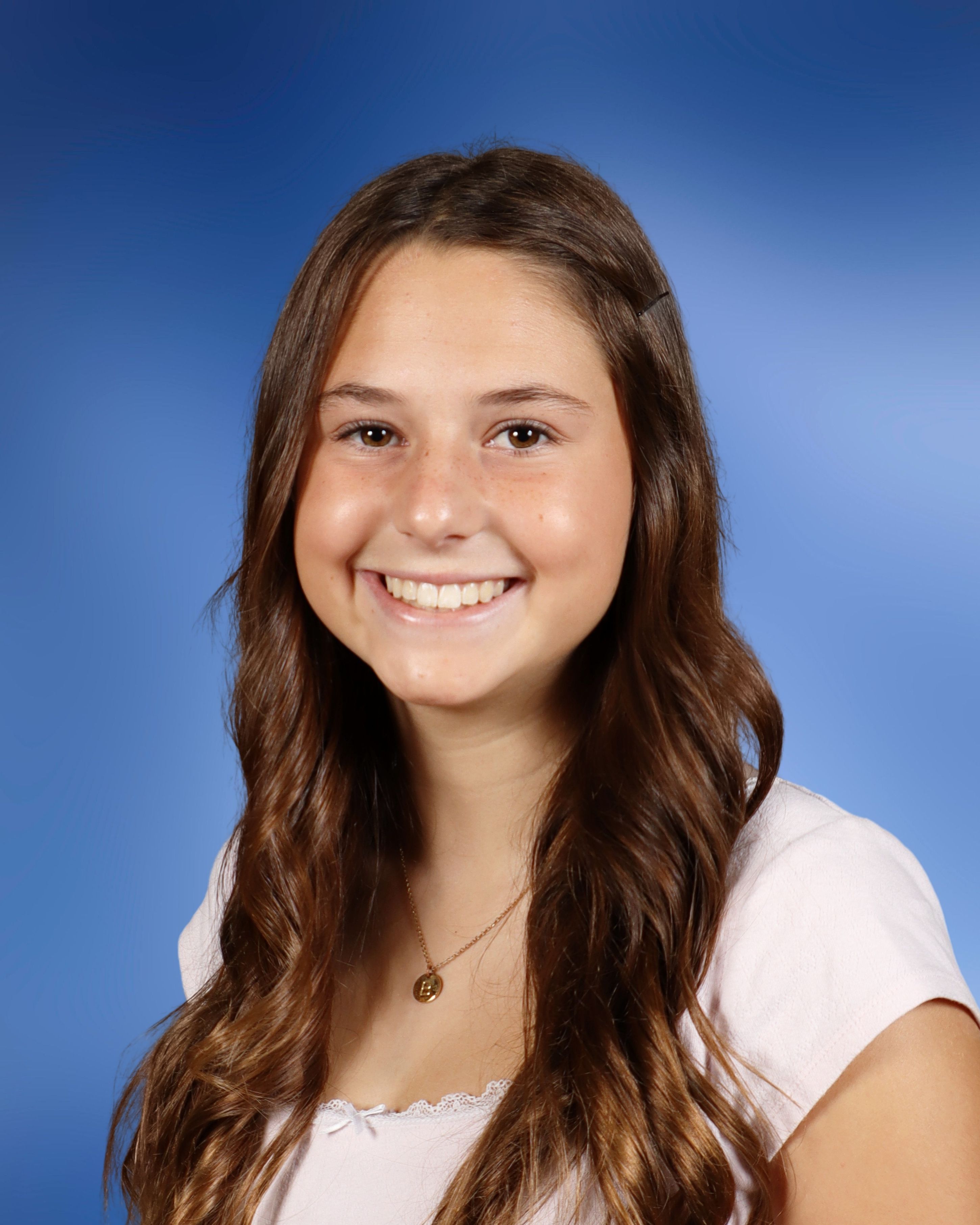 Middle school portrait — smiling student with blue studio backdrop